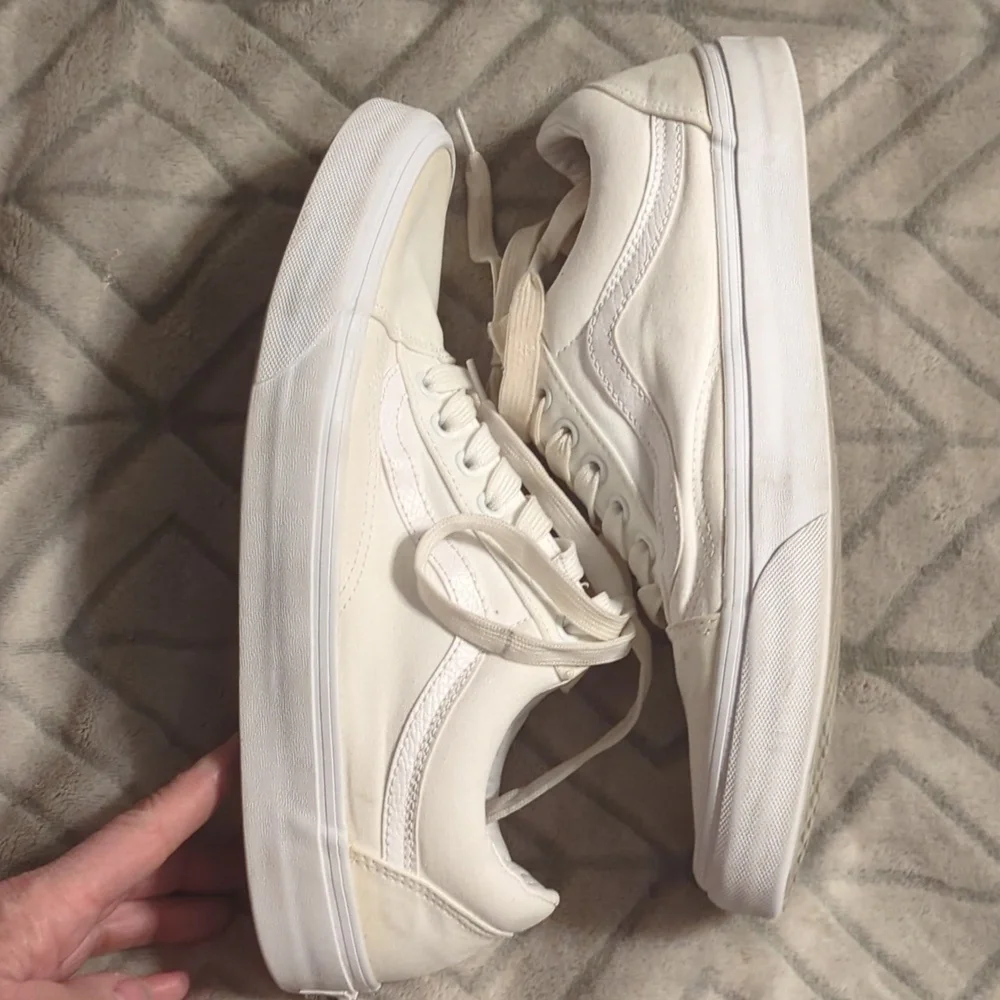 Vans Old Skool shoes in the True White or Monochrome‎ White colorway.